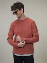 Buzo de frisa color gris topo, de corte clásico y cuello redondo.