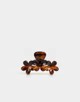 Broche de pelo color carey con forma de pinza y detalle de flores.
