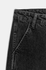 Pantalón de jean negro con lavado gastado, corte culotte, tiro alto, bolsillos delanteros y traseros, y cierre frontal con cremallera y botón.