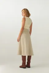 Falda midi evasé color beige, tejida en lana fina con detalle de pespuntes y cierre oculto.