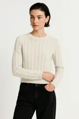Sweater color crudo de acrílico con ochos, corte holgado y cuello redondo.