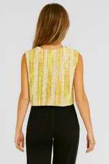 Chaleco tejido sin mangas con patrón a rayas verticales en tonos amarillo y crema.