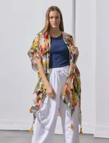 Kimono tejido con estampado abstracto multicolor, mangas amplias estilo japonés y terminación de ruedo con borlas amarillas.