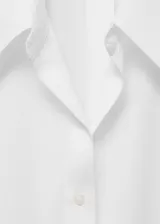 Camisa blanca sin mangas con cuello camisero y cierre frontal con botones.