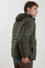 Campera capitoneada color bordó con capucha desmontable con cierre, dos bolsillos exteriores con cierre y un bolsillo interior.