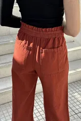 Pantalón de jean color beige, de corte ancho, recto y tiro alto. Tiene elástico y pinzas en la pretina.