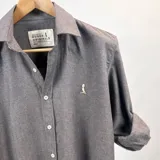 Camisa gris de algodón peletizado con textura leñadora, de manga larga y corte clásico.