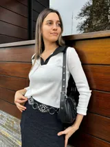 Remera de manga larga blanca con cuello polo negro.