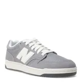 Championes New Balance modelo 480 Lifestyle, color gris con detalles en blanco. Presentan una silueta de corte bajo inspirada en el baloncesto, con capellada de gamuza y malla, y logo "N" blanco en los laterales. La suela es de goma en dos tonos: blanco y gris oscuro.