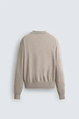 Sweater tipo polo color beige, de punto con mezcla de algodón y lana, corte regular fit, cuello solapa con abertura en V y mangas largas con terminaciones en rib.