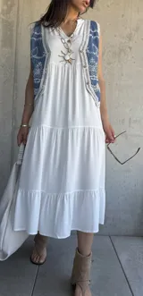 Vestido largo blanco de corte amplio con volados en el ruedo.