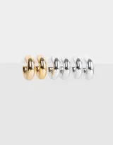 Set de tres pares de aros tipo argolla con diferentes texturas, un par dorado y dos plateados.