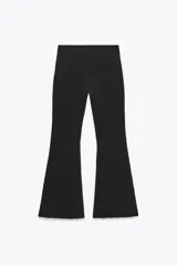 Pantalón negro de tiro alto, corte ajustado y cintura elástica. El ruedo es acampanado y está decorado con perlas.