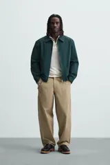 Pantalón color caqui de corte amplio, con pinzas en la cintura, bolsillos laterales y traseros con botón.