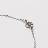 Pulsera plateada de acero con tres pequeños dijes circulares con incrustaciones de circonitas.