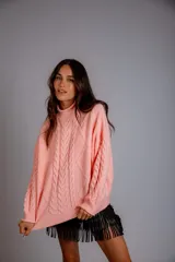 Sweater tejido de punto color rosa pastel, con cuello alto y diseño de trenzas verticales.