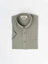 Camisa de hombre color verde oliva, de manga corta y corte clásico. Confeccionada en lino y poliéster, con cuello abotonado y bolsillo en el pecho.