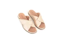 Sandalias bajas color vainilla, con tiras cruzadas y suela anatómica de poliuretano.