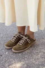 Mocasín de cuero color verde oliva, con cordones y suela marrón.