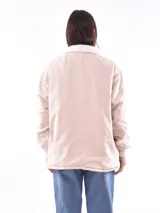 Campera de color beige claro, con forro suave y cierre frontal.