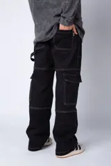 Pantalón cargo negro de corte relaxed fit y tiro medio, con múltiples bolsillos y costuras a contraste en color blanco.