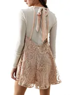 Mameluco corto color rosa pálido con lentejuelas doradas, escote halter y espalda descubierta.