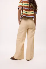 Pantalón recto color amarillo con rayas verticales blancas.