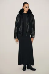 Vestido largo negro, corte recto, con cuello halter que se ata en la nuca y espalda descubierta.