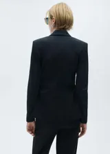 Blazer negro entallado con cuello de pico con solapa, bolsillo de ribete en el pecho, solapas con muesca, diseño recto, detalles fruncidos, dos bolsillos delanteros de ribete y solapa, cierre delantero con botones y forro interior.