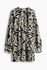Vestido corto en mezcla de viscosa con estampado floral en blanco y negro, cuello mao fruncido y abertura en V adelante. Modelo de corte holgado con cinturón extraíble para atar en la cintura, y mangas globo largas de corte raglán con abertura y botón en los puños.