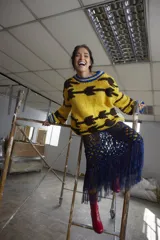 Sweater tejido a mano en lana color amarillo con diseño abstracto en marrón y detalles en azul en cuello y puños. De calce holgado, cuello a la base y puños ajustados.