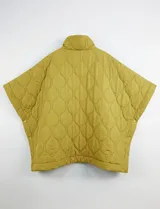 Poncho acolchado color mostaza con cuello alto y abertura frontal con cierre. Presenta un patrón capitoné de formas ovaladas y bolsillos delanteros.