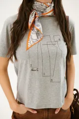 Remera blanca de algodón con cuello redondo y estampado de patrones de costura en el frente.