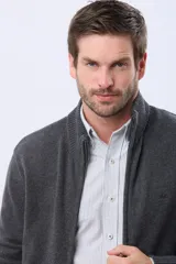 Campera tejida de lana color azul marino, con cuello alto, cierre metálico frontal y bolsillos laterales. Presenta detalles en cuero y logo bordado.