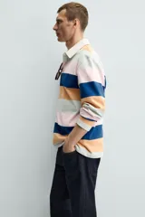 Polo de hombre de corte regular, con cuello solapa y cierre frontal de botonadura oculta por solapa, y manga larga. Diseño a rayas horizontales en azul marino, naranja, rosa y verde agua.