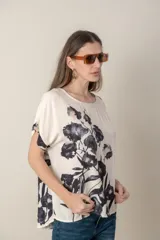Blusa italiana de calce holgado, talle único, con cuello redondo y mangas cortas. Estampado de flores sobre fondo natural.