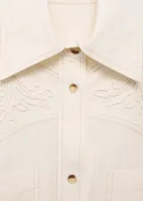 Camisa color crema de corte oversize con bordado floral en hombros y bolsillos.