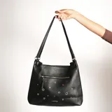 Cartera al hombro negra de cuero sintético con textura granulada y apliques metálicos.