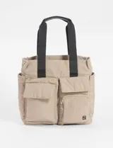 Bolso tipo shopper color beige con asas de mano negras y múltiples bolsillos externos con cierre y solapa.