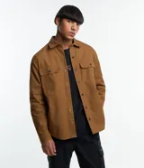 Camisa marrón de manga larga, confeccionada en sarga, con cuello inglés, abotonado delantero, bolsillos en el pecho con solapa y puños abotonados.