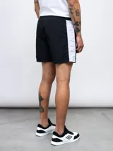 Short de baño negro con una franja vertical celeste con diseño estampado en el lateral.