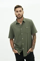 Camisa de manga corta color beige, con textura tipo crepé y cuello camisero.