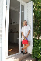 Camisa verde de lino, corte holgado, con cuello tejido a cuadros rojos y negros, botones multicolor y bolsillo en el pecho.