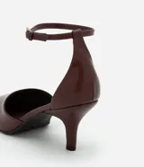 Zapato de tacón color marrón con punta fina, tira fina con hebilla lateral para cierre y tacón fino.