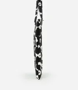 Funda para notebook con diseño tipo cartera, confeccionada en algodón con estampado floral bicolor en blanco y negro. Tiene cierre de cremallera y asa mediana.