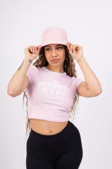 Remera corta de jersey color rosa con cuello redondo y mangas cortas con ribete blanco. Estampado frontal con la inscripción "ST-TROPEZ" en letras blancas.