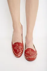 Ballerinas color verde oliva con calados geométricos y fondo dorado.