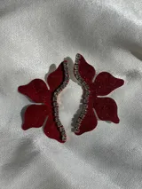 Aros colgantes con forma de flor roja con glitter, detalle de strass y gancho de acero quirúrgico.