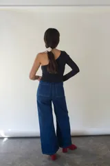 Top negro de un hombro, confeccionado en tejido rib suave y reciclado con elasticidad, generado a partir de desechos de nylon reciclados.