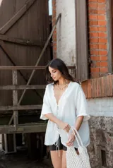 Blusa blanca de mangas cortas con volados, escote en V y lazo de ajuste.